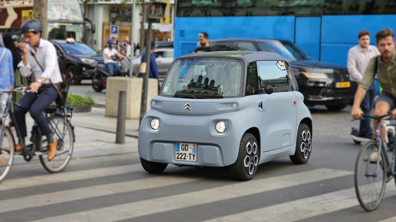 A Citroën Ami driving around a European city