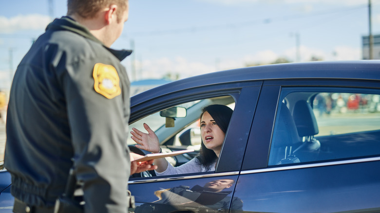 Woman, upset and traffic officer with ticket for checkpoint, security and crime investigation on highway.