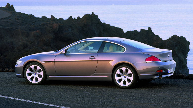Rear 3/4 view of a gray BMW 6 Series in front of a rock