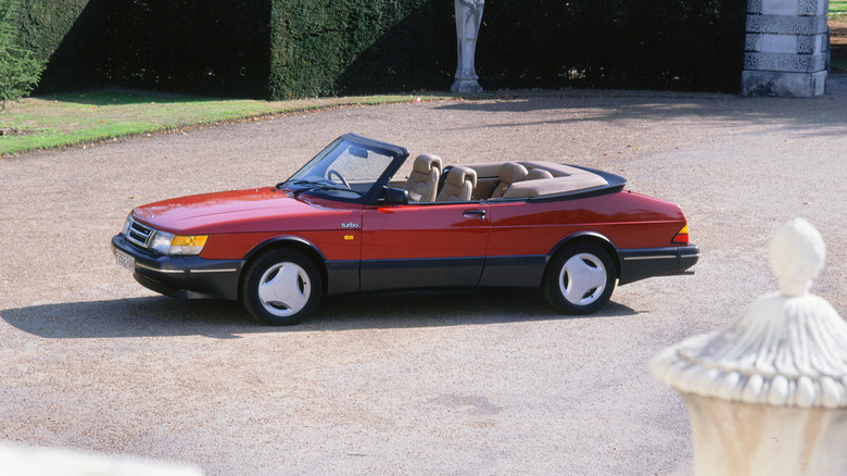 a red saab 900 turbo convertible parked in a driveway