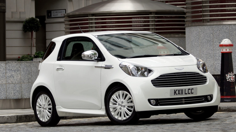 Aston Martin Cygnet parked in front of industrial building