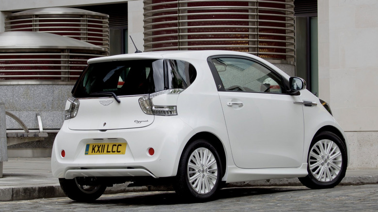 Aston Martin Cygnet parked in front of industrial building
