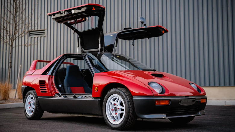 A red, plastic-cladded 1992 Autozam AZ-1 with white wheels and its gullwing doors opened.