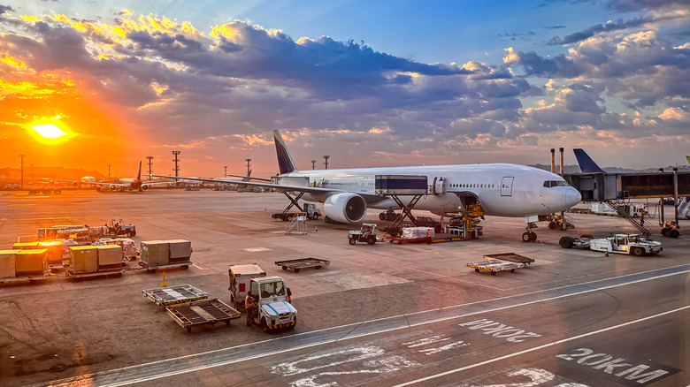 An unmarked plane parked at an airport gate