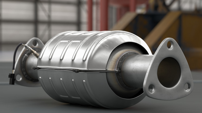 A new catalytic converter lies on its side on a floor.
