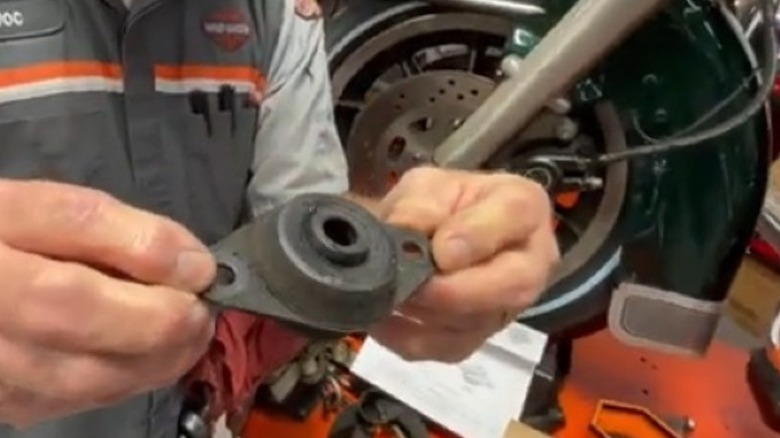 Doc Harley holding a rubber engine mount for a 1980-2008 Harley-Davidson touring bike.