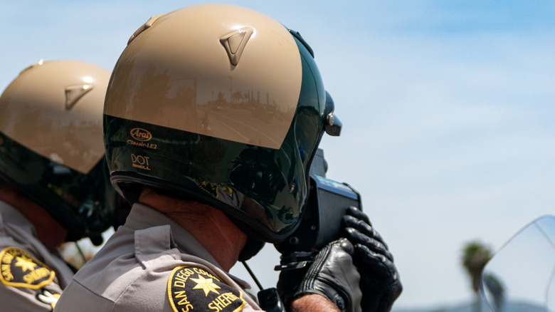 Two San Diego County Sheriff's Office law enforcement officers measure motorists' speed with a radar gun
