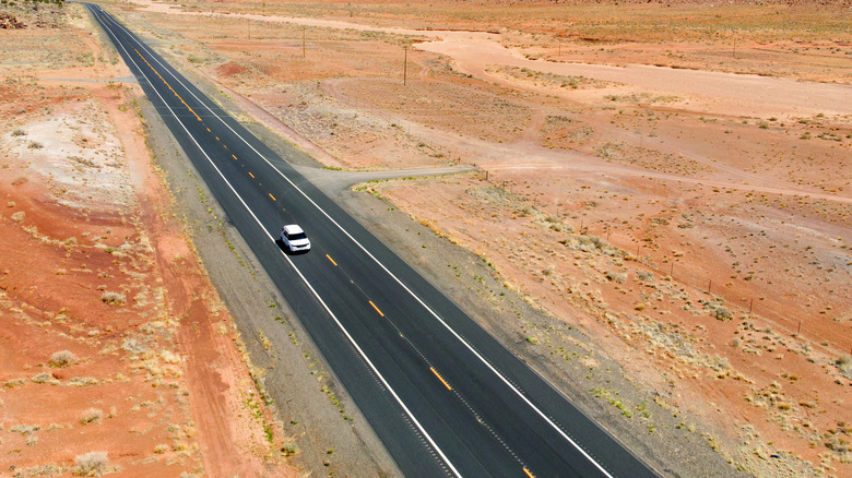 Aerial view of a lone car driving on a highway in Utah