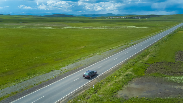 A car driving on a long straight road