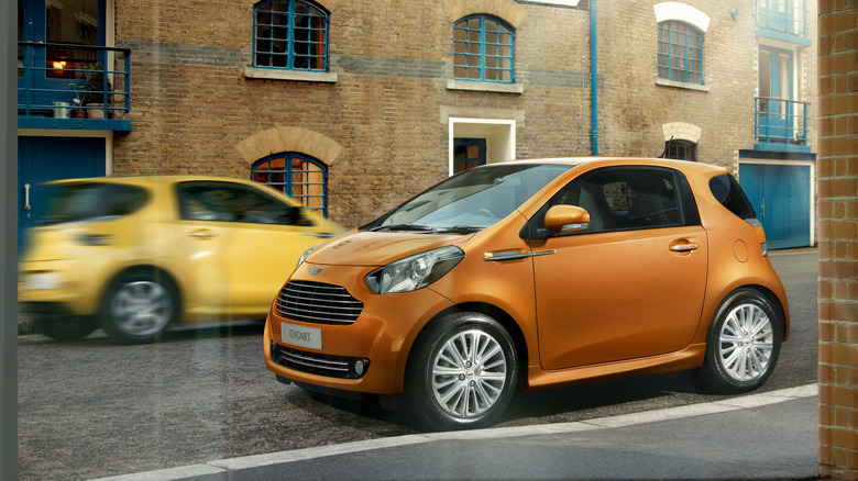An orange Aston Martin Cygnet parked on the street