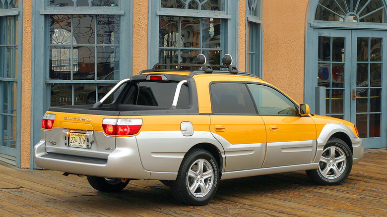 Rear 3/4 view of a yellow Subaru Baja with silver cladding