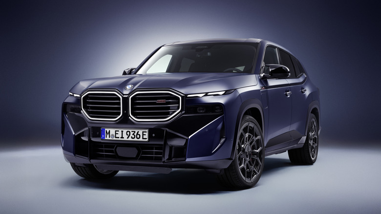 A blue 2026 BMW XM on display in a studio setting.
