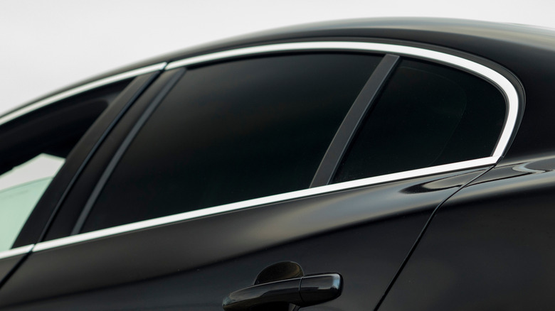 Rear tinted windows on a black car.