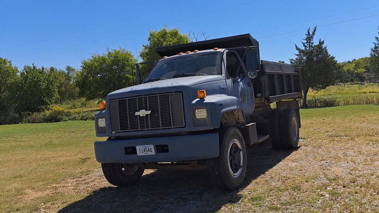 A 1995 Chevrolet Kodiak dump truck on grassy terrain