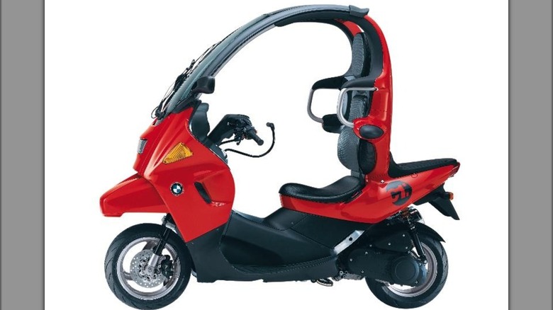 A red BMW C1 125 gas-powered scootered produced from 1999-2002 which still contains remnants of the second concept scooter including the actual seat and ceiling.