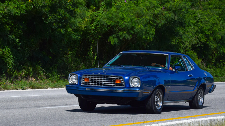 Blue Ford Mustang II on the road