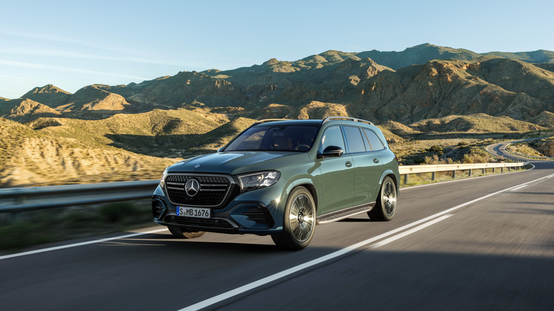 A green Mercedes-Benz GLS on a roadway.