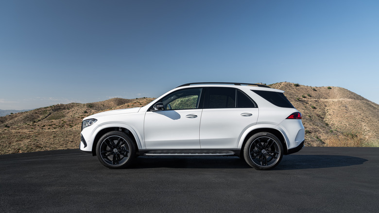 A white Mercedes-Benz GLE in front of a hill.
