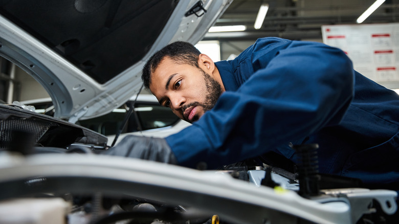 A mechanic working on an engine in a repair shop