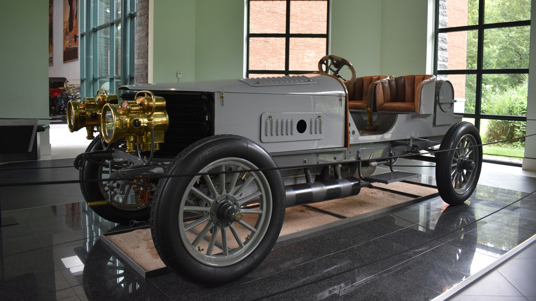 A gray 1903 Spyker with the industry's first I6 engine on display at a museum, front 3/4 view