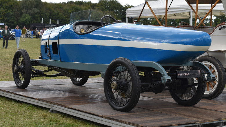 The Spyker C4 race car on display at a classic car show, rear 3/4 view, blue exterior