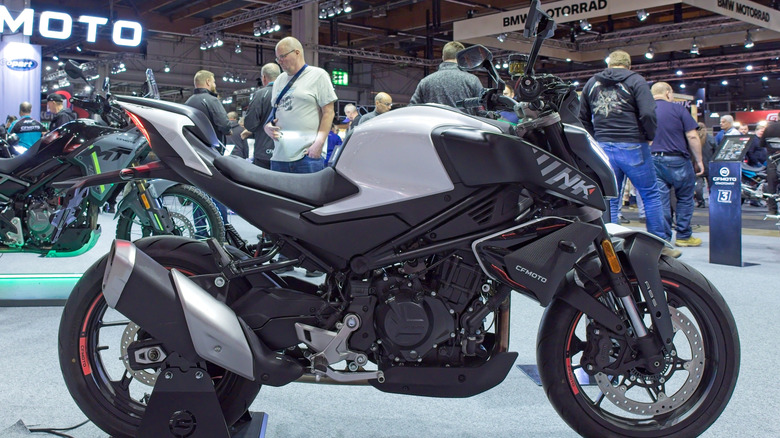 a gray and black CFMoto motorcycle parked at an auto expo