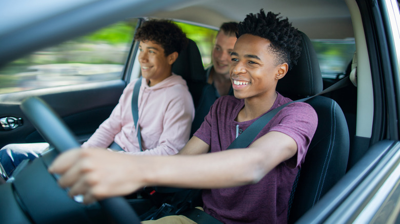 A teenager driving a car with their friends inside