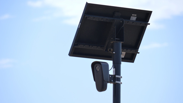 A Flock camera seen against a pale blue sky