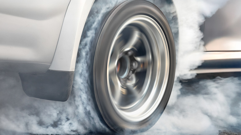 Car tire smoking while peeling out.