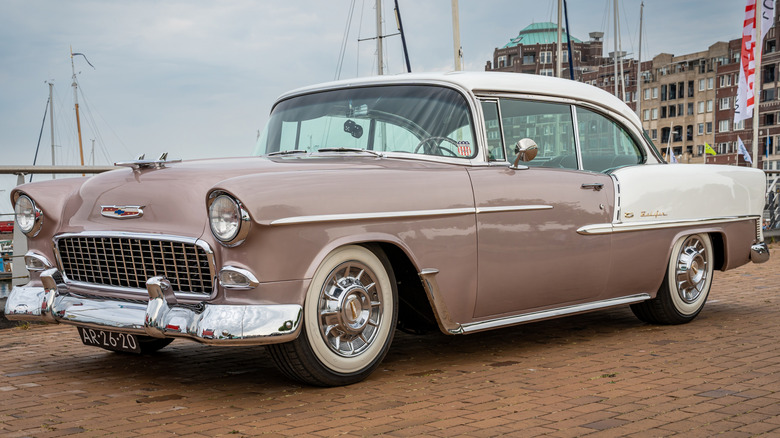 A brown and white 1955 Chevrolet Bel-Air with a wraparound windshield
