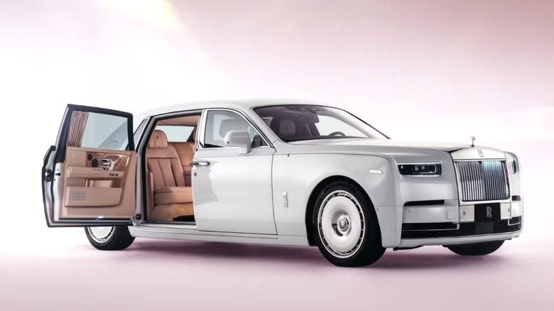 a white rolls-royce with coach doors parked in a pink liminal space