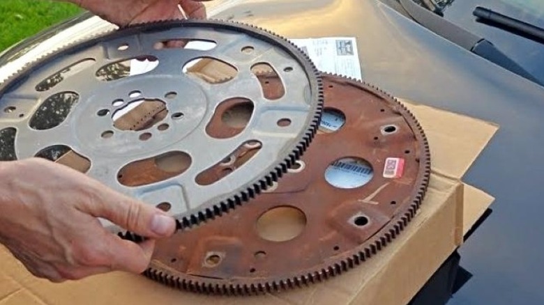 A new flex plate being held up against an old unit