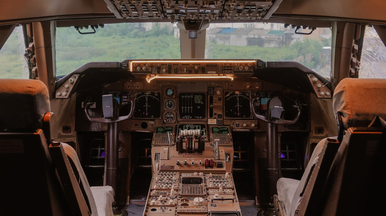 A photo of the inside of the cockpit or pilot's room of a Boeing 747 aircraft, vintage film grained filter. The actual aircraft is being displayed for photo nowadays