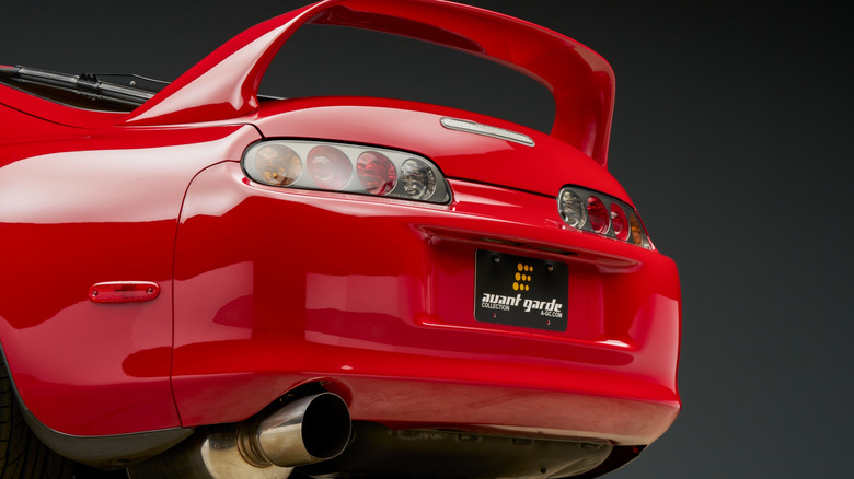 Low left view of red Toyota Supra MKIV with spoiler