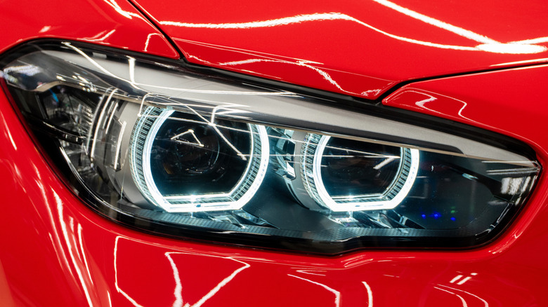A red BMW sports car's headlights.