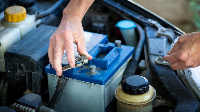 Man installing the terminals to the car battery