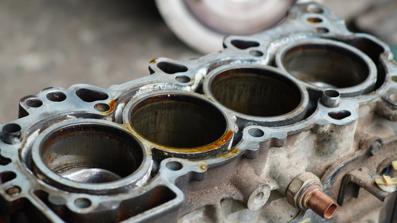 A four-cylinder engine with the head removed and cylinders exposed.