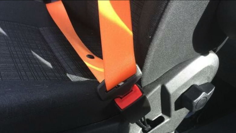 An orange webbed seatbelt in a Sprinter van.
