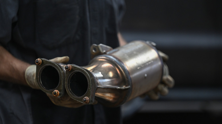 Mechanic holding a catalytic converter