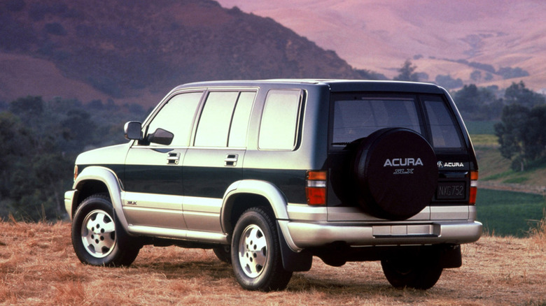 A two-tone 1996 Acura SLX SUV parked on grass