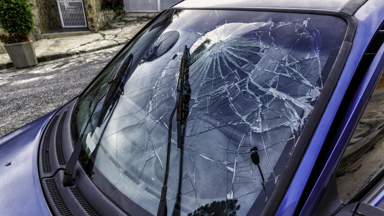 Smashed front windshield of a blue car
