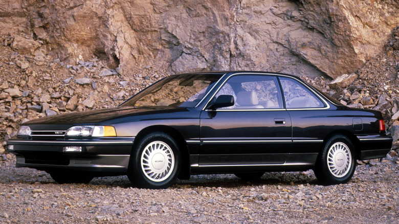 A black 1987 Acura Legend coupe parked on a gravel road.
