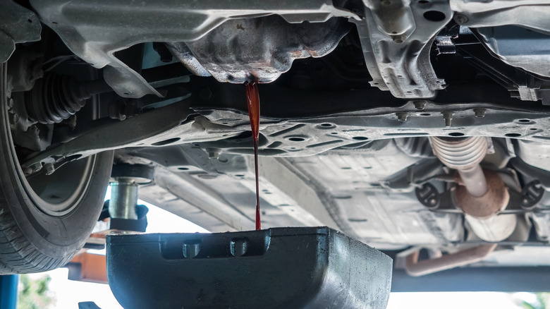 Oil draining into a pan from a car engine