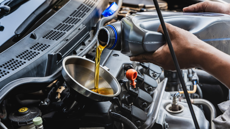 Pouring fresh engine oil into the engine