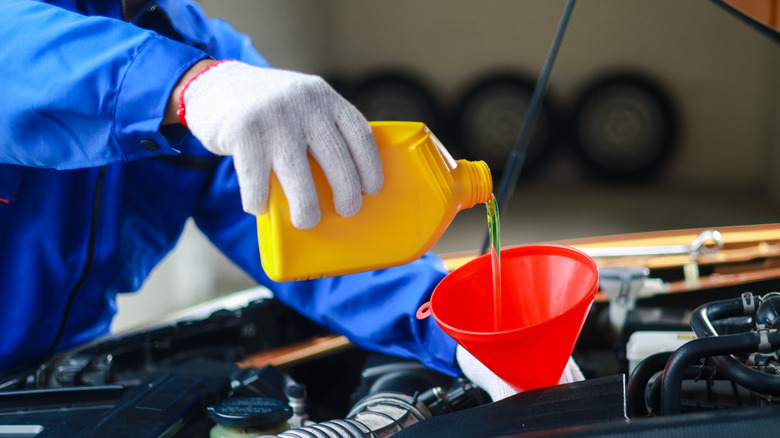Mechanic pouring oil in the engine