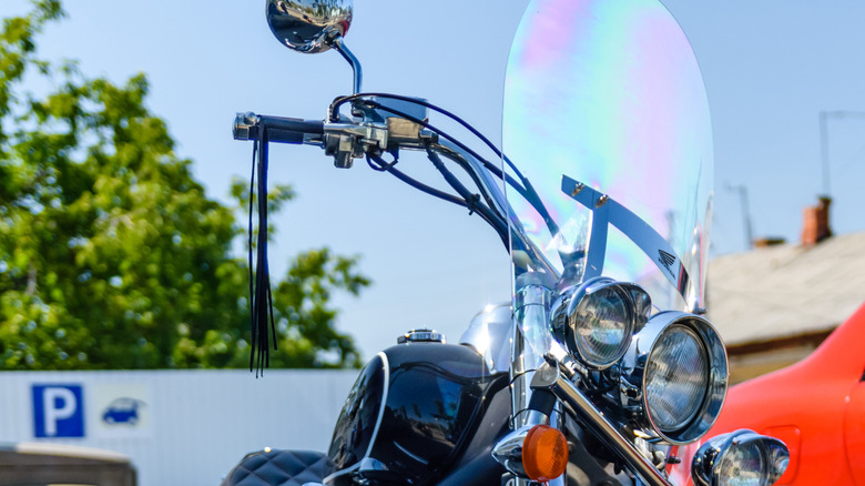 A vintage motorcycle with a get-back whip on the handlebar