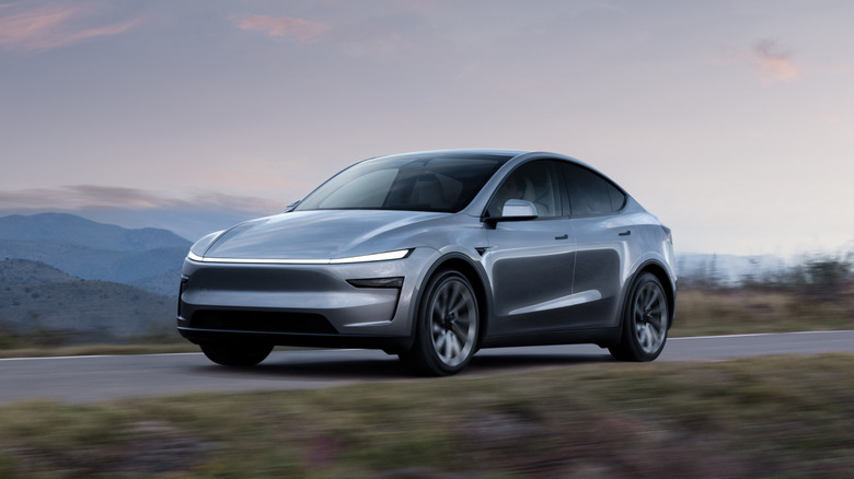 Front 3/4 view of a silver Tesla Model Y in motion.