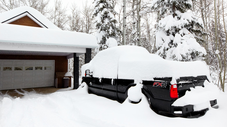 A heavy-duty pickup in Canada parked outside and covered in snow