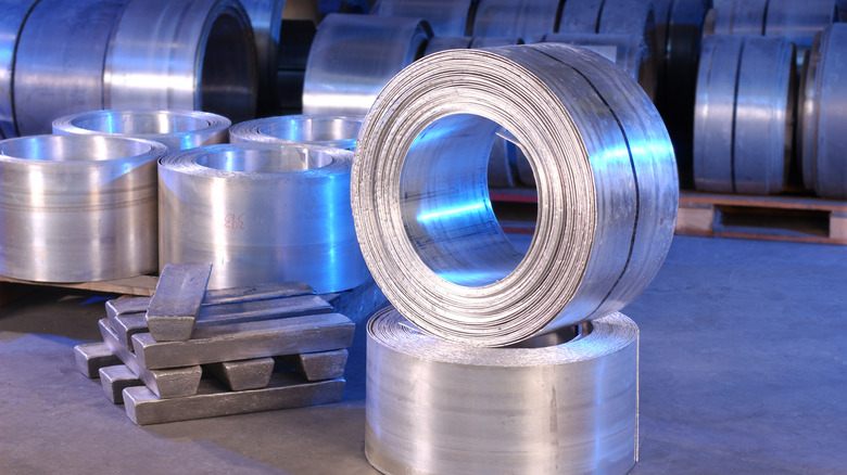 Coiled magnesium sheets and magnesium ingots.