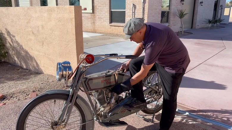 A man kick-starting a 1915 Harley-Davidson 11F